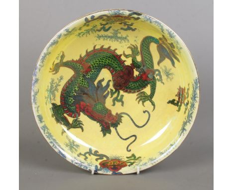 A Bursley Ware 'Dragon' ceramic bowl, decorated with central dragon motif, gilt highlights and foliage, on a pale yellow back