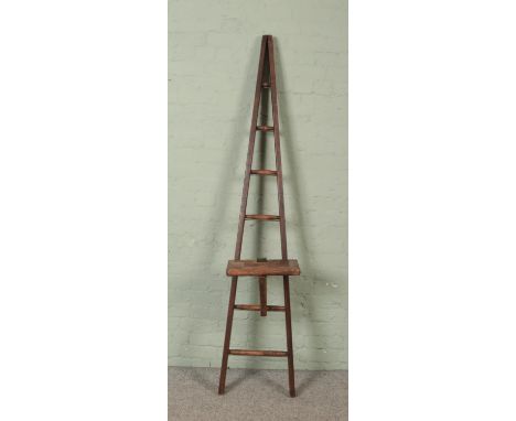 A seven rung wooden A-Frame ladder, possibly for fruit picking, with a platform step. Height: 204cm.  