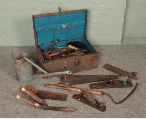 A vintage tin trunk with contents of tools along with a galvanised watering can. Includes Stanley planes, saws, screw drivers