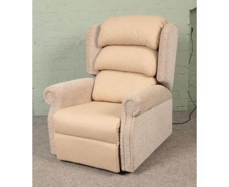 A 2023 model Repose electric riser/recliner armchair, with remote, in cream upholstered fabric. Complete with instruction man