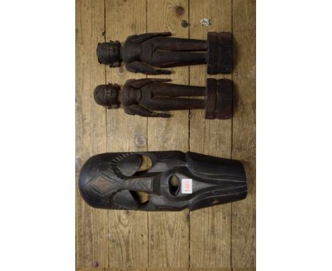 Ethnographica: a pair of Burmese hardwood figures, 31.5cm high; together with another tribal mask. 