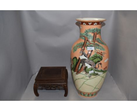 A large oriental styled lamp base, having orange ground with storks amongst shrubbery, chip to rim, also included is a carved