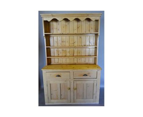 A Late 19th Century Pine Dresser, the boarded shelf back above a lower section with two drawers above two cupboard doors, 137