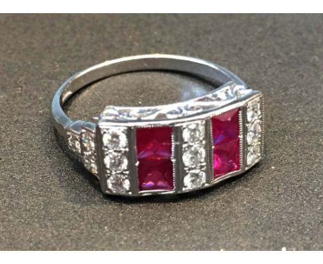 An 18ct. White Gold Art Deco Style Ruby and Diamond Ring set with four rubies and nine diamonds with diamond shoulders within