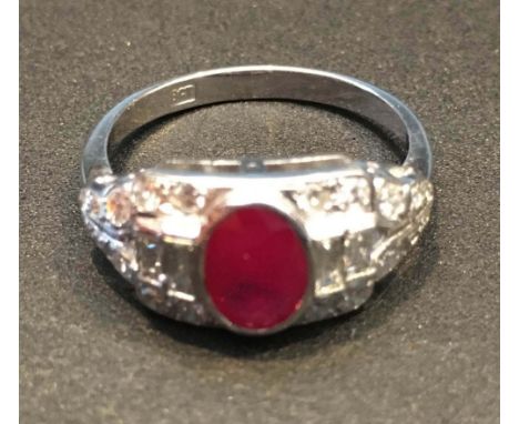 An 18ct. White Gold Ruby and Diamond Ring with a central oval ruby surrounded by diamonds, approximately 0.50 / 0.90 ct.