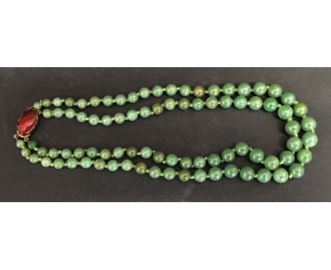 A Chinese Green Jade Graduated Bead Double Necklace with gold clasp