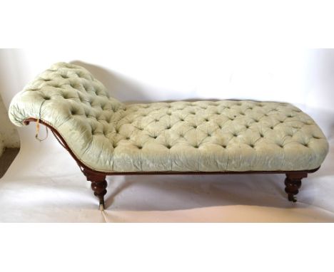 A Victorian Mahogany Chaise Longue with button upholstered scroll end raised upon turned legs with casters