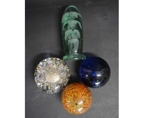 A Group Of Four Early Glass Paperweights, to include one set with a military button and three others
