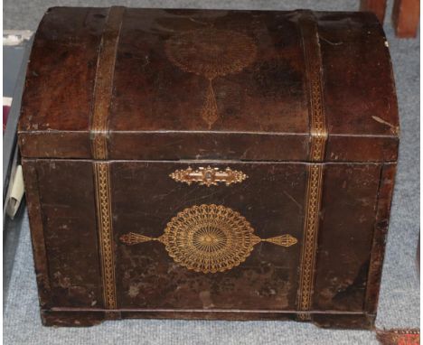 A brown leather and gilt tooled cabinet, in the form of a dome top trunk, with hinged lid enclosing a fall front and divided 