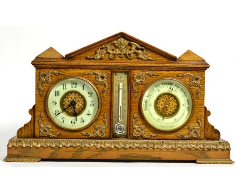 An Edwardian gilt metal mounted oak cased combination clock, barometer and thermometer; the barometer dial signed ''Made in P
