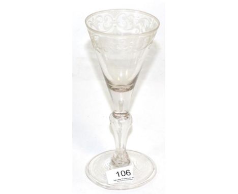 A light baluster wine glass, circa 1750, the funnel bowl engraved with a band of scrolling foliage, on a baluster stem and fo