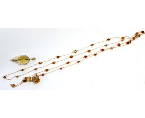 A citrine necklace, a continuous fine chain with citrine set links at intervals, suspending a citrine set thistle pendant and
