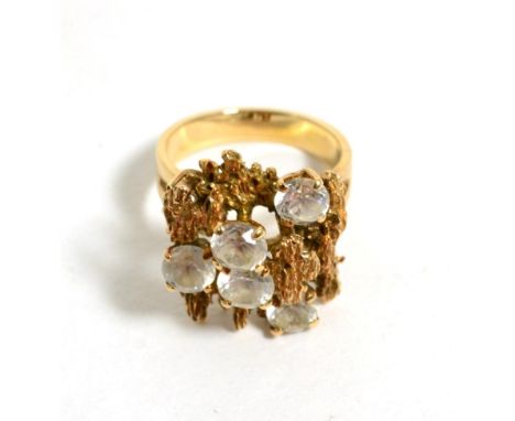 A 1970s cubic zirconia cluster ring, round cut cubic zirconia to a textured bar top, finger size M1/2, stamped '14K'7.5g