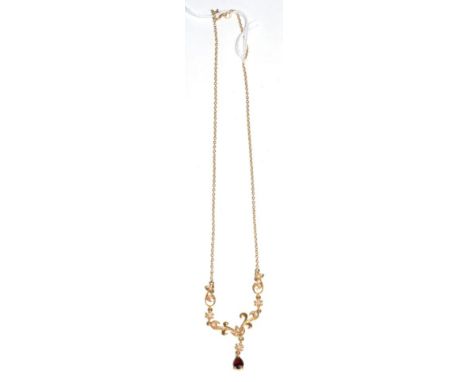 An Edwardian style 9 carat gold seed pearl and garnet necklace, a pear cut garnet suspended from an articulated seed pearl se