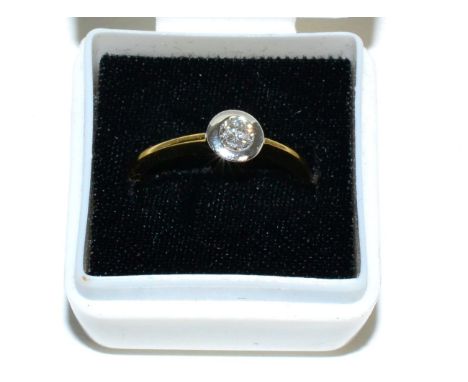 An 18 carat gold solitaire diamond ring, a round brilliant cut diamond in a broad rubbed over setting, to knife edge shoulder