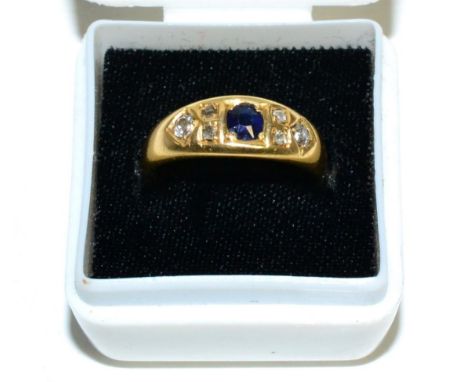 An 18 carat gold sapphire and diamond ring, a round cut sapphire spaced by groups of old cut diamonds inset to a tapering sha