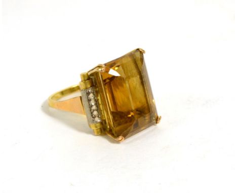 A citrine ring, an octagonal cut citrine in a double claw setting, to fancy scroll shoulders, finger size L1/2The citrine mea