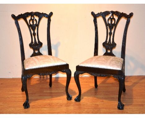 A pair of Chippendale style mahogany dining chairs, raised on cabriole ball and claw supports, 103cm high
