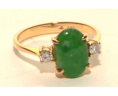 A 14ct gold jade and diamond ring, the central oval green jade cabochon (approx 1.93ct) surmounted by two brilliant cut diamo