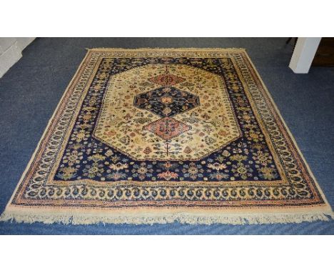 An Eastern style rug, the triple central blue and pink diamonds over cream ground, with navy surround and cream and pink mult