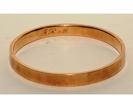 A 9ct gold bangle, inscribed with initials 'JRM' to inside, stamped 9ct, 6.5cm diameter, 12.3g