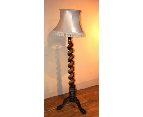 A Victorian mahogany spiral column floor lamp with shade, raised on carved tripod supports, 180cm high