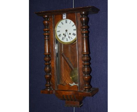 An early 20th century mahogany Vienna wall clock, with glazed door enclosing white enamel dial with Roman numerals, 71cm high