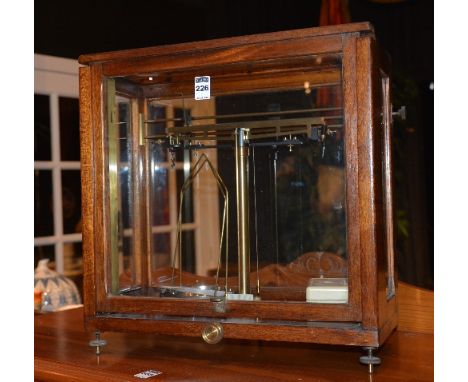 A set of vintage scientific scales by Baird & Tatlock, in glazed display case