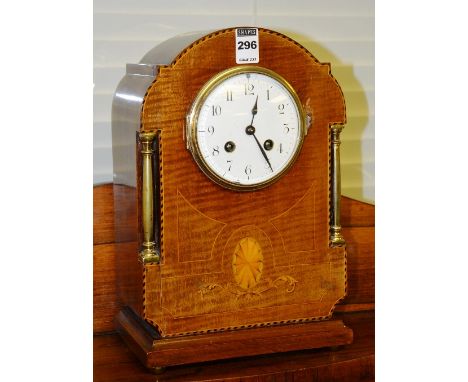 An Edwardian mahogany inlaid mantel clock, with French movement and white enamel dial, flanked by brass columns, 31cm high