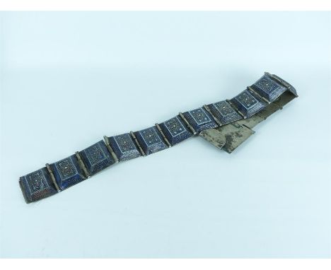 An Arabian white metal belt with enamel and glass inlays of blue, green and red.
