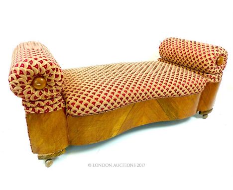 A 1930s Art Deco walnut veneered double scroll ended lift up ottoman, raised on four casters, 148cm wide, upholstered in red 