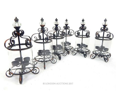 A set of six painted and distressed wrought iron storm lanterns, each with a glass finial and space for four candles, 38 x 20