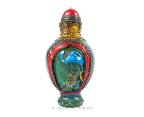 A Chinese Peking glass scent bottle, with red hardstone stopper, carved with a portrait of a bearded gentleman, the verso car