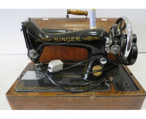 Vintage Singer sewing machine in a wooden case with key.