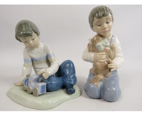 2 Nao figurines of little boys one with a puppy and one with a train. 