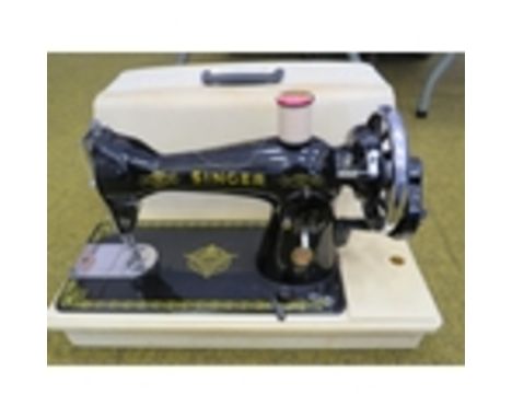 Vintage singer sewing machine in plastic case.