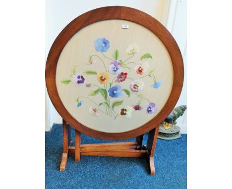 Pretty small round table with needlepoint decoration of Pansies under glass top.  Top folds down to make fire screen. See pho