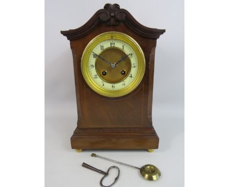 French wooden mantel clock with enamel face and standing on brass bun feet, Fully working, Approx 11.5" tall and 7" wide.