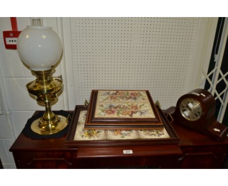 A pair of tiled mahogany trays, brass carry handles; a mahogany mantel clock, a brass oil lamp (4)