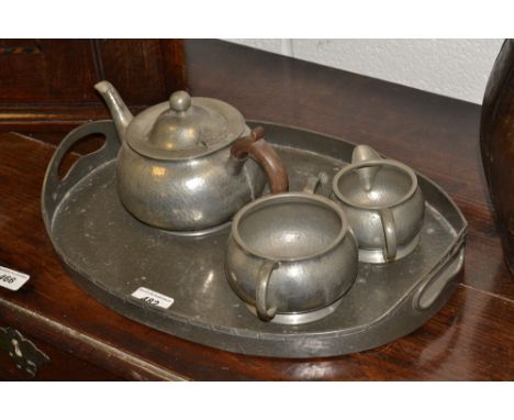 An Abbey pewter tray;  a three-piece pewter tea service (4)