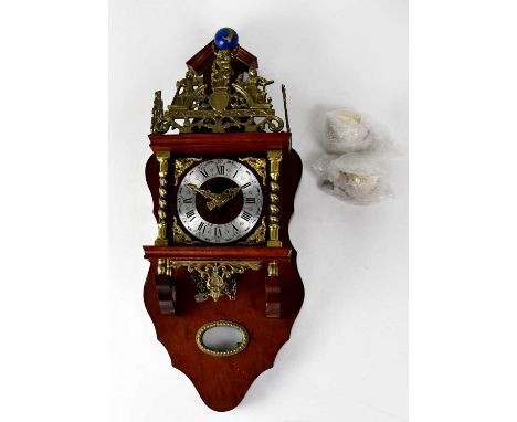 A reproduction Dutch wall clock with wooden case and pierced brass mounts, all surmounted by a figure holding a globe, the ch