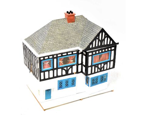 A Tudor-style dolls' house, double front door with rooms to the interior, with furniture and figures, fitted for battery powe