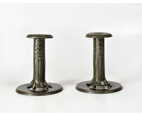 TUDRIC; a pair of pewter candlesticks by Archibald Knox, Design No. 022, each with stylised interwoven leaf motifs, on circul