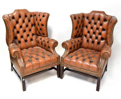 A pair of brown leather Chesterfield wingback armchairs with button backs and stud detail (2).Condition Report: - Both appear