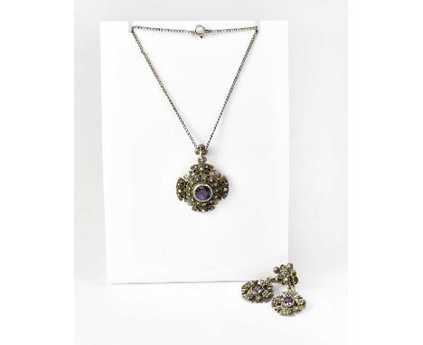 A circular silver pendant set with a purple/blue stone, diameter approx. 2.9cm, stamped 'Jerusalem Silver 935', on chain, wit