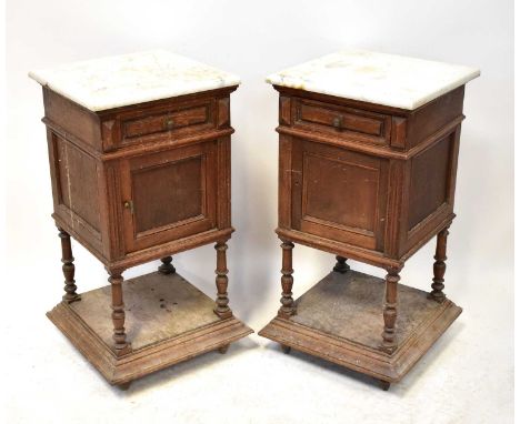 A pair of early 20th century French oak marble top pot cupboards, with single frieze drawer above panelled door, raised on tu