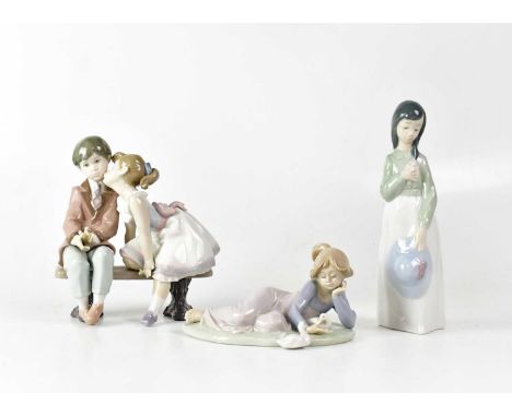 LLADRÓ; a boxed figure of a reclining young lady with ducks, no. 5609, length 16.5cm, a figure group of a boy and girl on a b