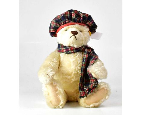 STEIFF; a golden bear wearing tartan scarf and bonnet, with growler, gold button and tag to ear, height 33cm.