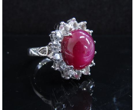 A cabochon star ruby and white topaz ring stamped 925. Size N, 6.8g, with certificate