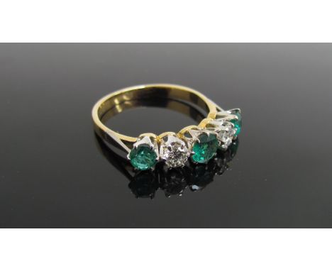 An emerald and diamond five stone ring, stamped 750/plat, .40ct diamond,  .90ct emerald. Size Q/R, 3.1g       